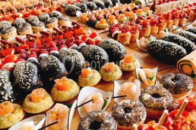 Gâteau à trois étages décoré de motifs dorés, plumes blanches et perles, avec une inscription d'anniversaire.