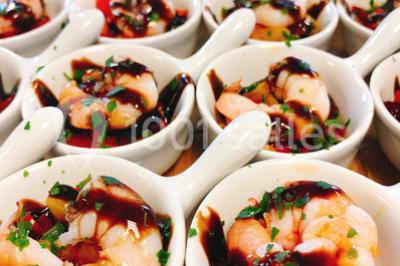 Gâteau à trois étages décoré de motifs dorés, plumes blanches et perles, avec une inscription d'anniversaire.