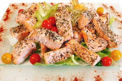 Gâteau à trois étages décoré de motifs dorés, plumes blanches et perles, avec une inscription d'anniversaire.