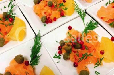 Gâteau à trois étages décoré de motifs dorés, plumes blanches et perles, avec une inscription d'anniversaire.