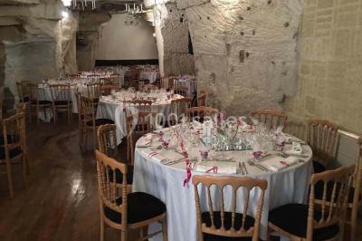 Gâteau à trois étages décoré de motifs dorés, plumes blanches et perles, avec une inscription d'anniversaire.