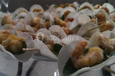Gâteau à trois étages décoré de motifs dorés, plumes blanches et perles, avec une inscription d'anniversaire.
