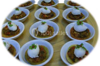 Gâteau à trois étages décoré de motifs dorés, plumes blanches et perles, avec une inscription d'anniversaire.