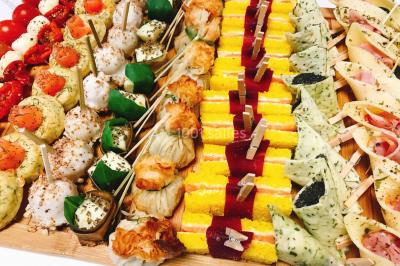 Gâteau à trois étages décoré de motifs dorés, plumes blanches et perles, avec une inscription d'anniversaire.