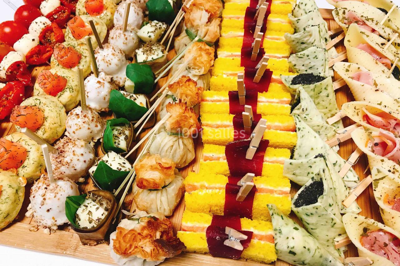 Plateau de bouchées variées comprenant légumes, fromages, feuilletés, et amuse-bouches colorés.