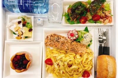 Gâteau à trois étages décoré de motifs dorés, plumes blanches et perles, avec une inscription d'anniversaire.