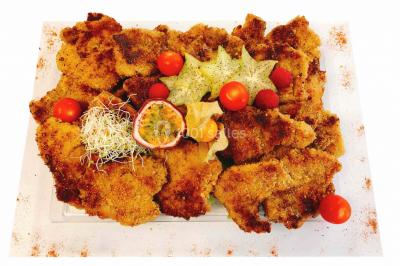 Gâteau à trois étages décoré de motifs dorés, plumes blanches et perles, avec une inscription d'anniversaire.