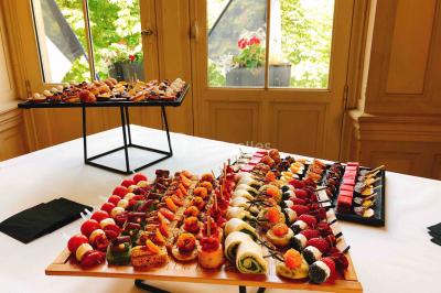 Gâteau à trois étages décoré de motifs dorés, plumes blanches et perles, avec une inscription d'anniversaire.
