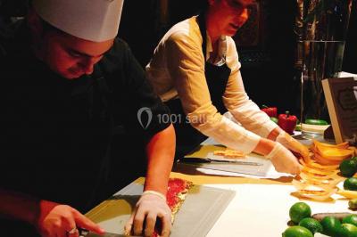 Gâteau à trois étages décoré de motifs dorés, plumes blanches et perles, avec une inscription d'anniversaire.
