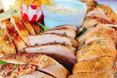 Gâteau à trois étages décoré de motifs dorés, plumes blanches et perles, avec une inscription d'anniversaire.