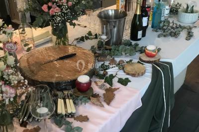 Gâteau à trois étages décoré de motifs dorés, plumes blanches et perles, avec une inscription d'anniversaire.
