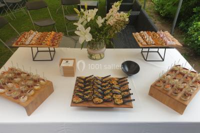 Gâteau à trois étages décoré de motifs dorés, plumes blanches et perles, avec une inscription d'anniversaire.