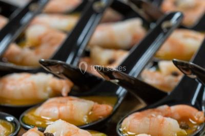 Gâteau à trois étages décoré de motifs dorés, plumes blanches et perles, avec une inscription d'anniversaire.