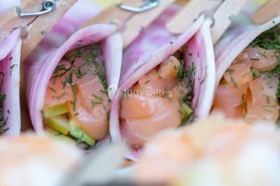 Gâteau à trois étages décoré de motifs dorés, plumes blanches et perles, avec une inscription d'anniversaire.