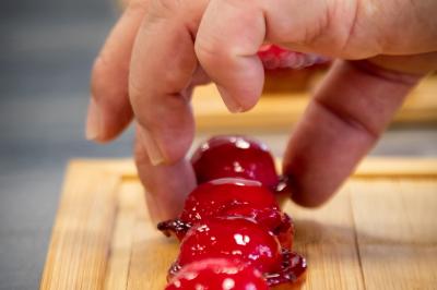 Gâteau à trois étages décoré de motifs dorés, plumes blanches et perles, avec une inscription d'anniversaire.