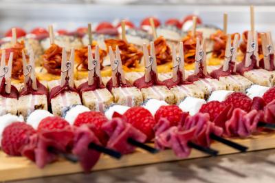 Gâteau à trois étages décoré de motifs dorés, plumes blanches et perles, avec une inscription d'anniversaire.