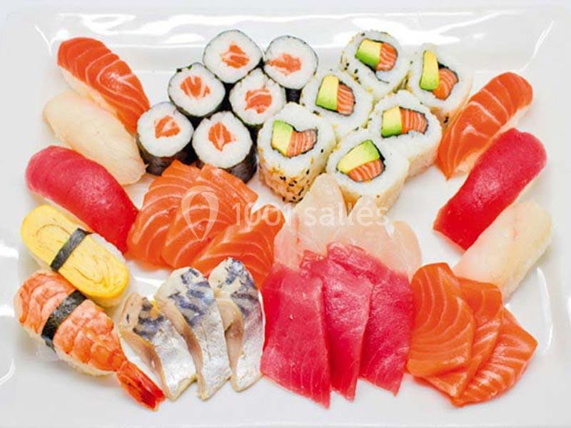 Plateau de sushis variés comprenant makis, nigiris et sashimis disposés sur une assiette blanche.