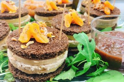 Logo d'un traiteur avec silhouette de chef et couverts, accompagné de photos de bouchées et plats variés colorés.