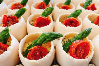 Logo d'un traiteur avec silhouette de chef et couverts, accompagné de photos de bouchées et plats variés colorés.