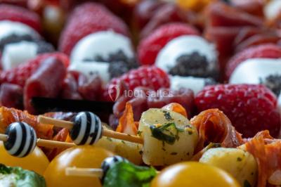 Logo d'un traiteur avec silhouette de chef et couverts, accompagné de photos de bouchées et plats variés colorés.