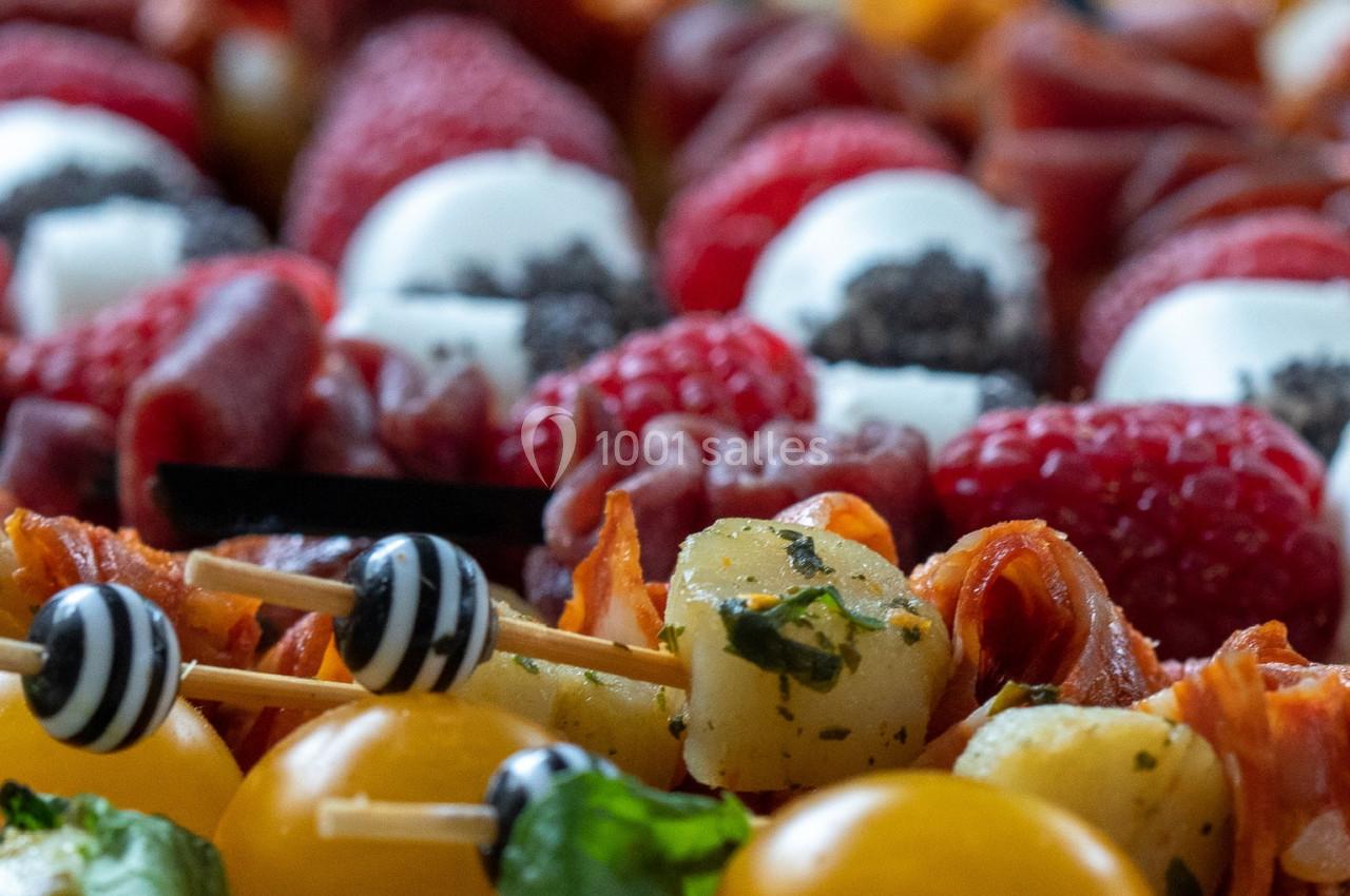 Assortiment de brochettes apéritives avec tomates cerises, fromage, fruits et charcuterie.