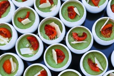 Table garnie de fruits variés et colorés, disposés artistiquement avec des feuilles tropicales en arrière-plan.