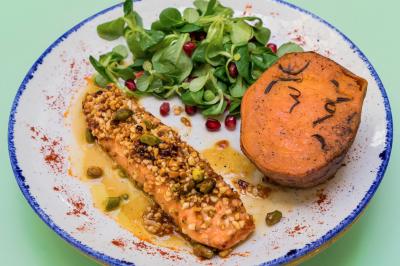 Table garnie de fruits variés et colorés, disposés artistiquement avec des feuilles tropicales en arrière-plan.