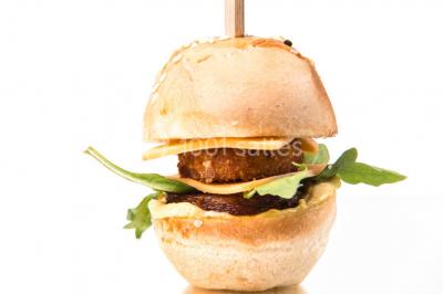 Une femme souriante se tient derrière un stand de produits variés dans une salle décorée avec un sapin de Noël.