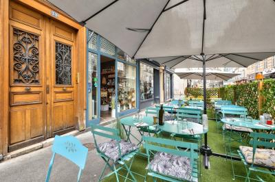 Une femme souriante se tient derrière un stand de produits variés dans une salle décorée avec un sapin de Noël.