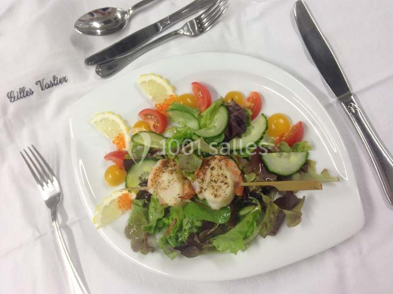 Assiette de salade composée avec brochette de noix de Saint-Jacques, légumes frais et quartiers de citron.