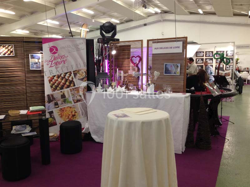 Stand de traiteur avec présentoirs, brochures, décorations et affiches promotionnelles dans un salon professionnel.