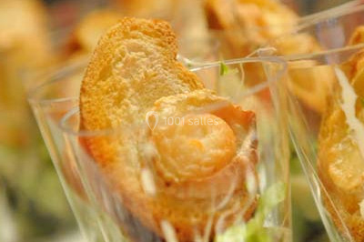 Salle de réception décorée avec des tables dressées, nappes blanches et touches de bleu, prête pour un événement.