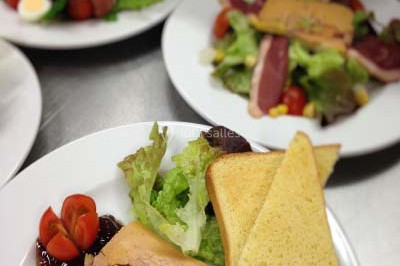 Salle de réception décorée avec des tables dressées, nappes blanches et touches de bleu, prête pour un événement.