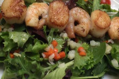 Salle de réception décorée avec des tables dressées, nappes blanches et touches de bleu, prête pour un événement.