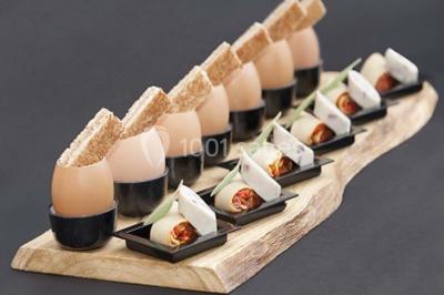 Boule panée garnie de pinces de crabe, posée sur une tranche de gratin, décorée d'aneth sur une assiette blanche.