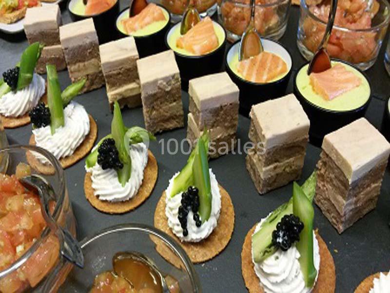 Assortiment de bouchées apéritives avec foie gras, verrines au saumon, et crackers garnis de crème et asperges.