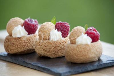 Boule panée garnie de pinces de crabe, posée sur une tranche de gratin, décorée d'aneth sur une assiette blanche.