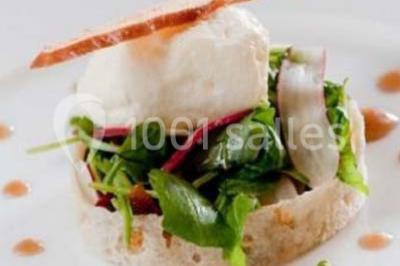 Boule panée garnie de pinces de crabe, posée sur une tranche de gratin, décorée d'aneth sur une assiette blanche.