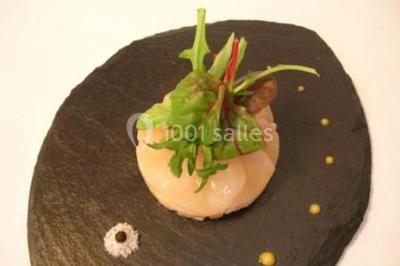 Boule panée garnie de pinces de crabe, posée sur une tranche de gratin, décorée d'aneth sur une assiette blanche.