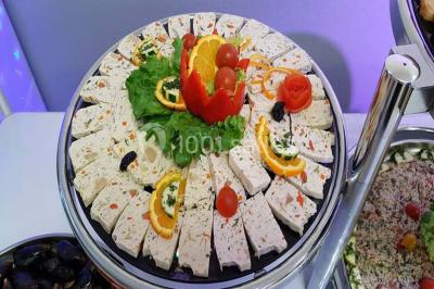 Plateau de pâté en croûte décoré de légumes frais, tranches de tomate, concombre et garniture de salade verte.