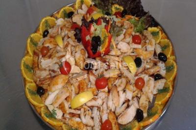 Plateau de pâté en croûte décoré de légumes frais, tranches de tomate, concombre et garniture de salade verte.