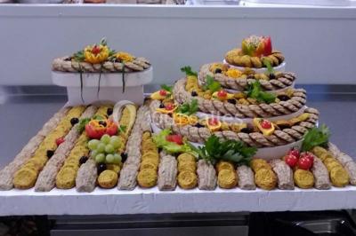 Plateau de pâté en croûte décoré de légumes frais, tranches de tomate, concombre et garniture de salade verte.
