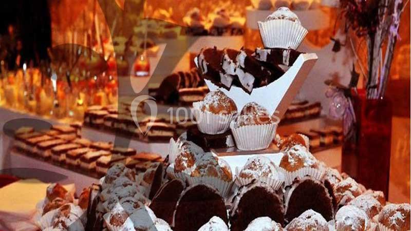 Plateau de pâtisseries variées, incluant muffins et gâteaux, présenté sur une table décorée pour un buffet.