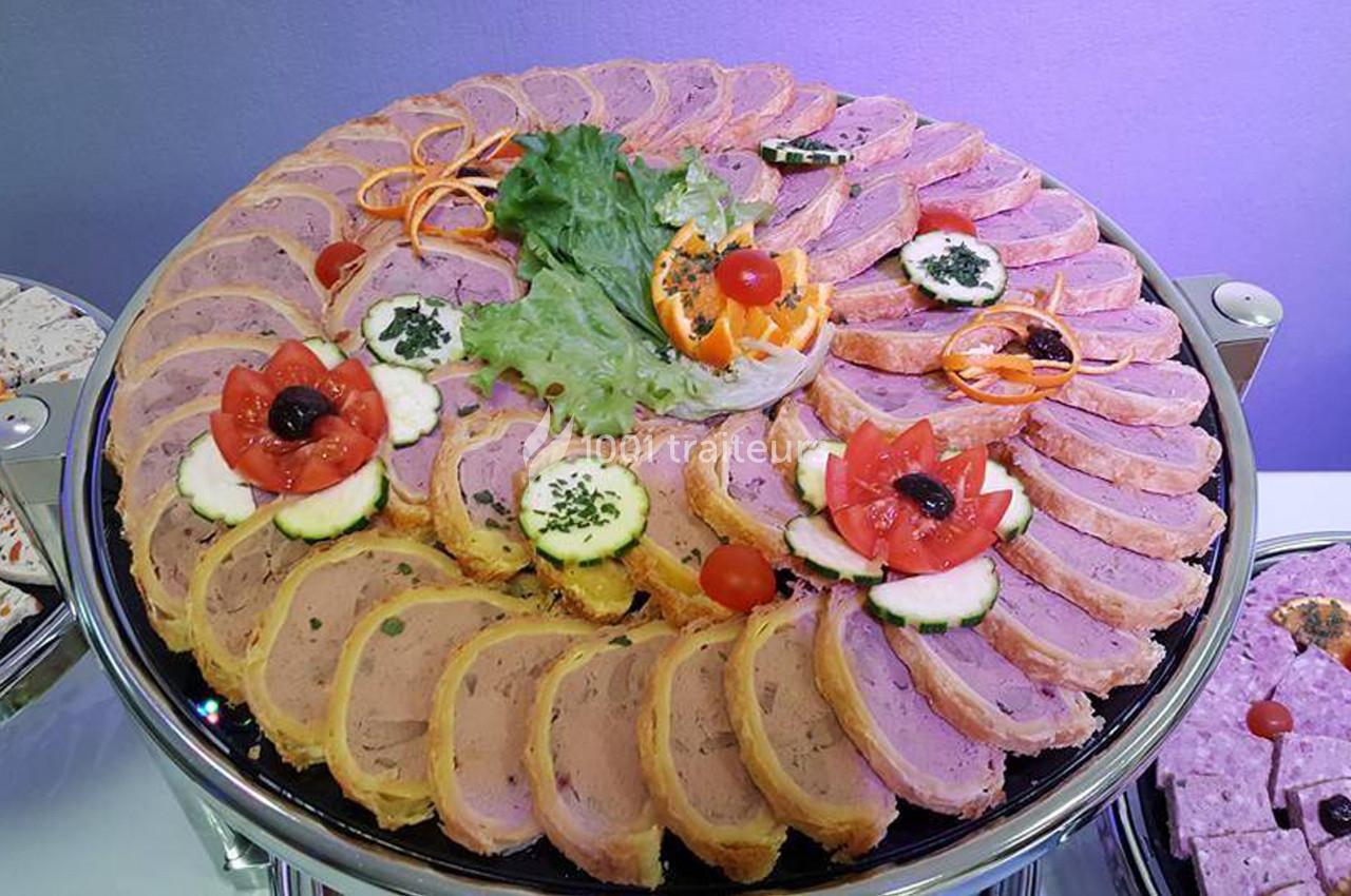 Plateau de pâté en croûte décoré de légumes frais, tranches de tomate, concombre et garniture de salade verte.