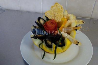 Buffet décoré avec des plats variés, incluant des fruits sculptés, des viandes et des desserts, sur des tables drapées de…