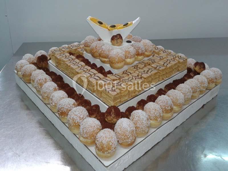 Plateau pyramidal de pâtisseries variées, incluant choux à la crème, millefeuilles et décoration en chocolat blanc.