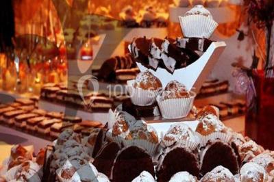 Buffet décoré avec des plats variés, incluant des fruits sculptés, des viandes et des desserts, sur des tables drapées de…