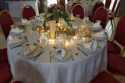 Buffet décoré avec des plats variés, incluant des fruits sculptés, des viandes et des desserts, sur des tables drapées de…