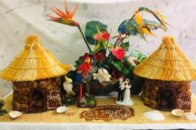 Buffet décoré avec des plats variés, incluant des fruits sculptés, des viandes et des desserts, sur des tables drapées de…