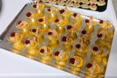 Buffet décoré avec des plats variés, incluant des fruits sculptés, des viandes et des desserts, sur des tables drapées de…